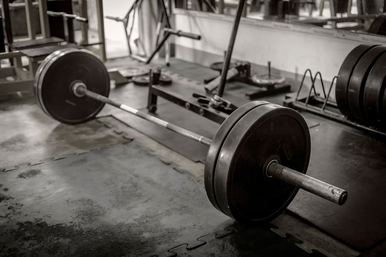 Barbell sits with weight on platform in gym