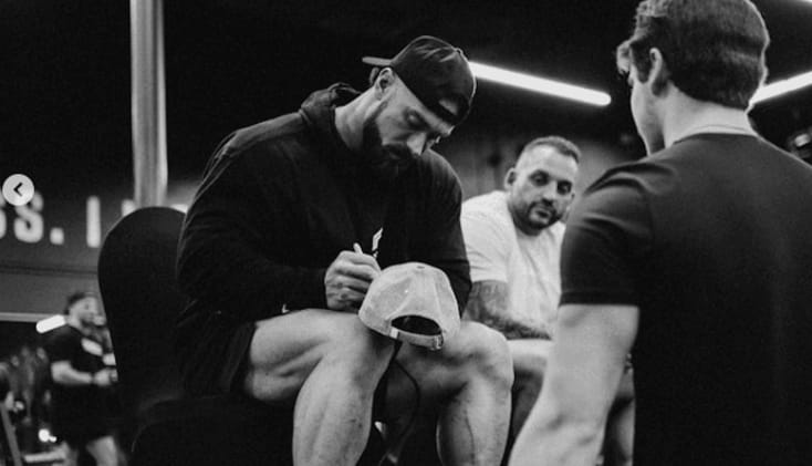 Chris Bumstead signing a hat