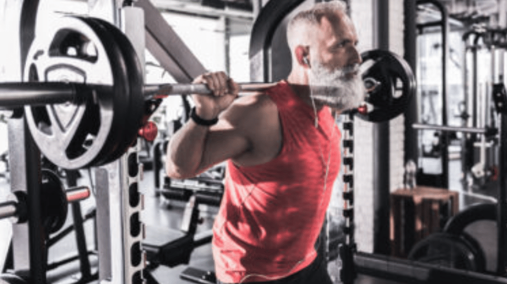 Older man with beard prepares to perform squat