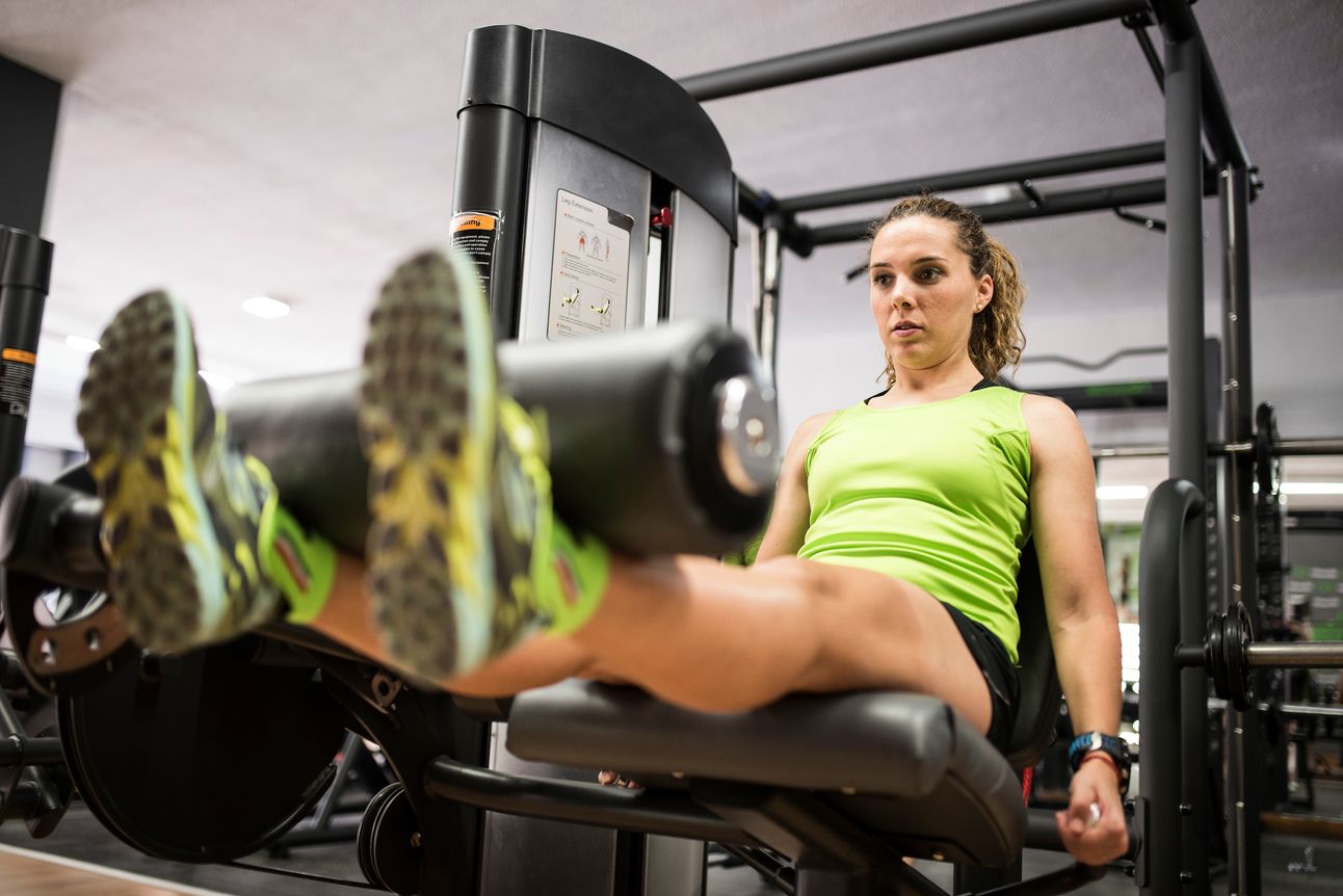 Woman performs a leg extension on a machine