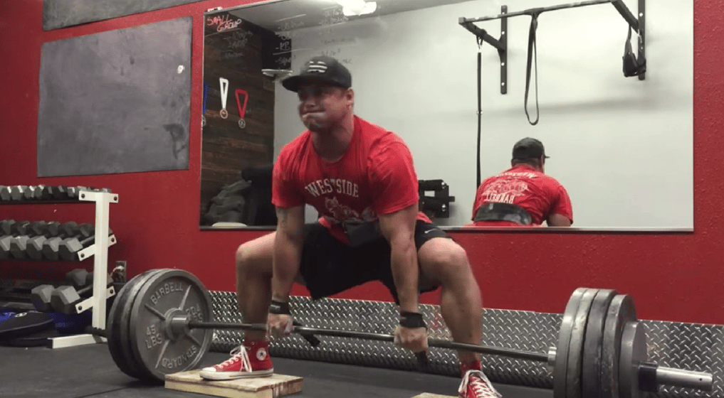 An athlete performs the deficit sumo deadlift