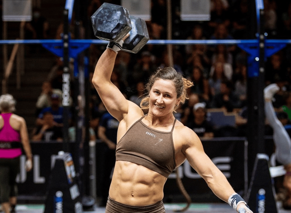 Tia-Clair Toomey smiling with a dumbbell in hand. 