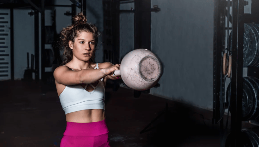 An athlete swings a kettlebell