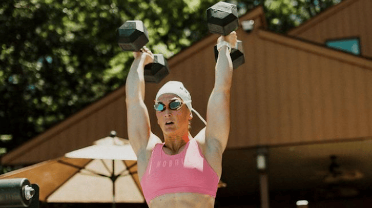 Tia-Clair Toomey holding dumbbells before jumping in a pool.